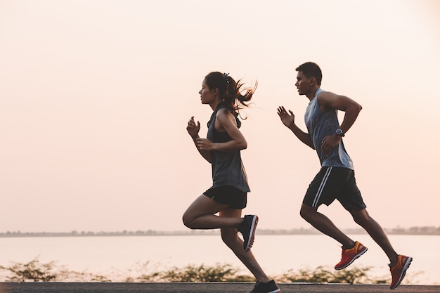 Young couple runner running on running road in city park Premium Photo